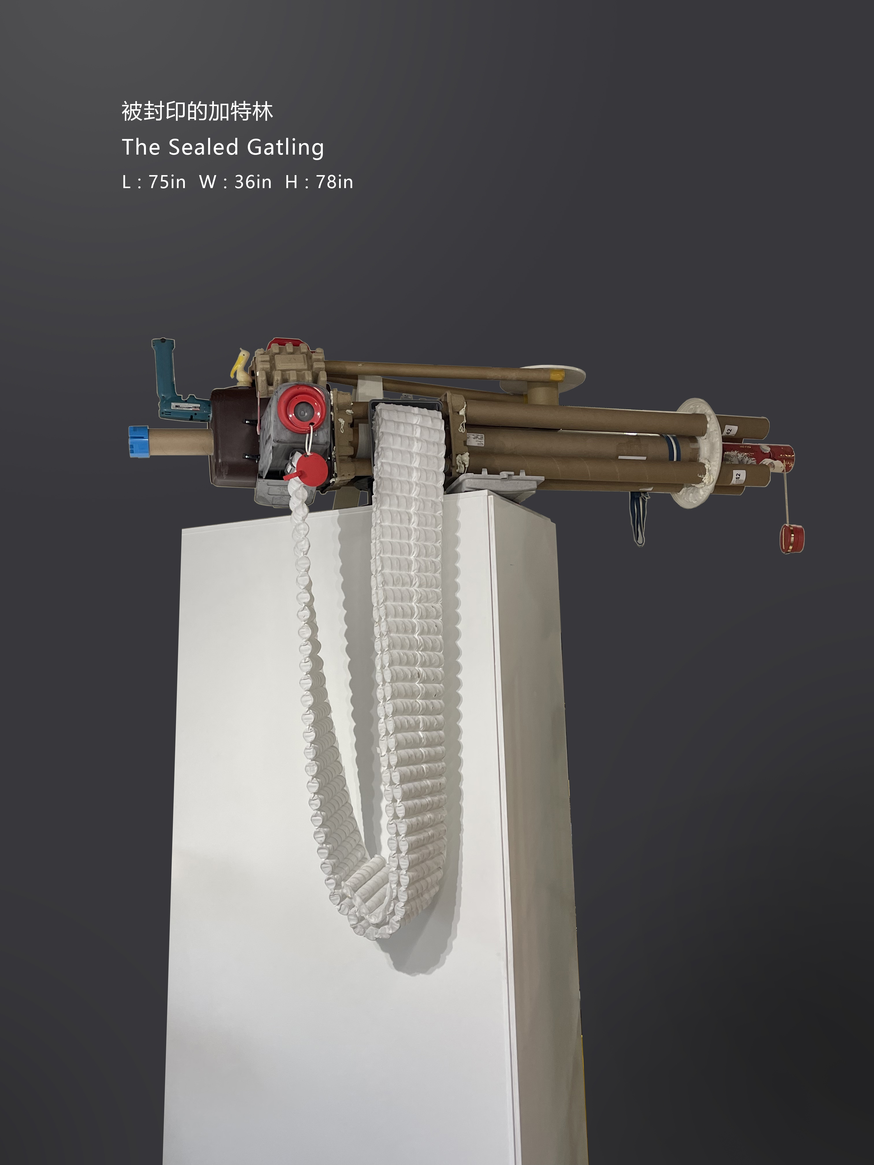 The Sealed Gatling, an assemblage of paper tubes, plastic and reclaimed materials on a tall pedestal